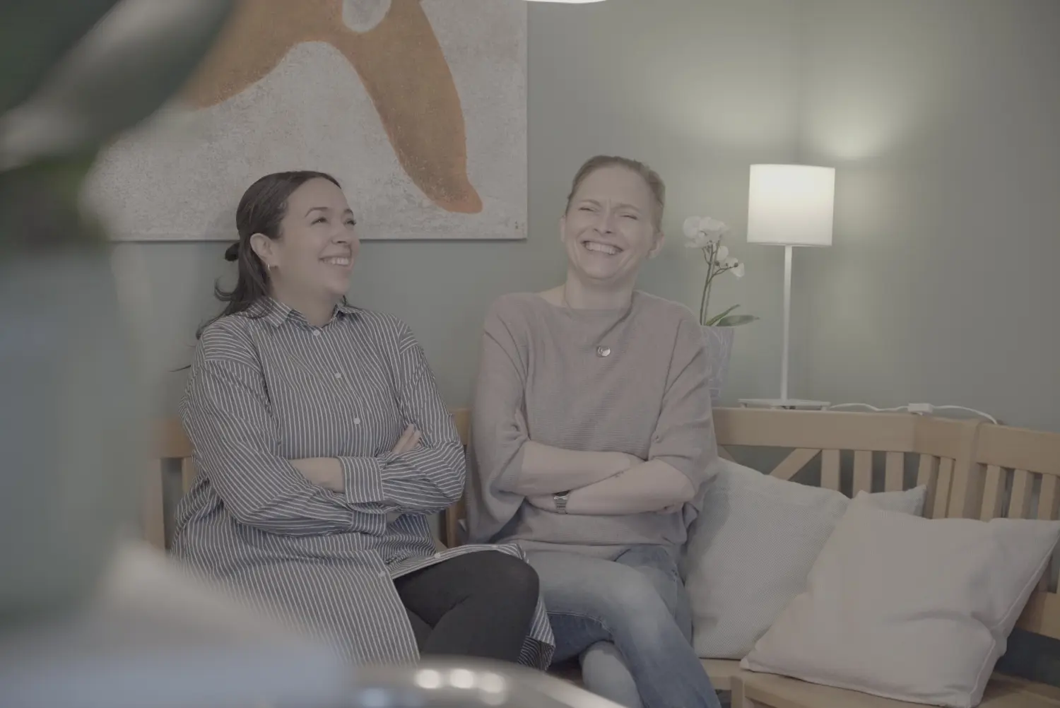 Thouraya und Wanda, die auf der Bank sitzen und Kaffeetassen halten