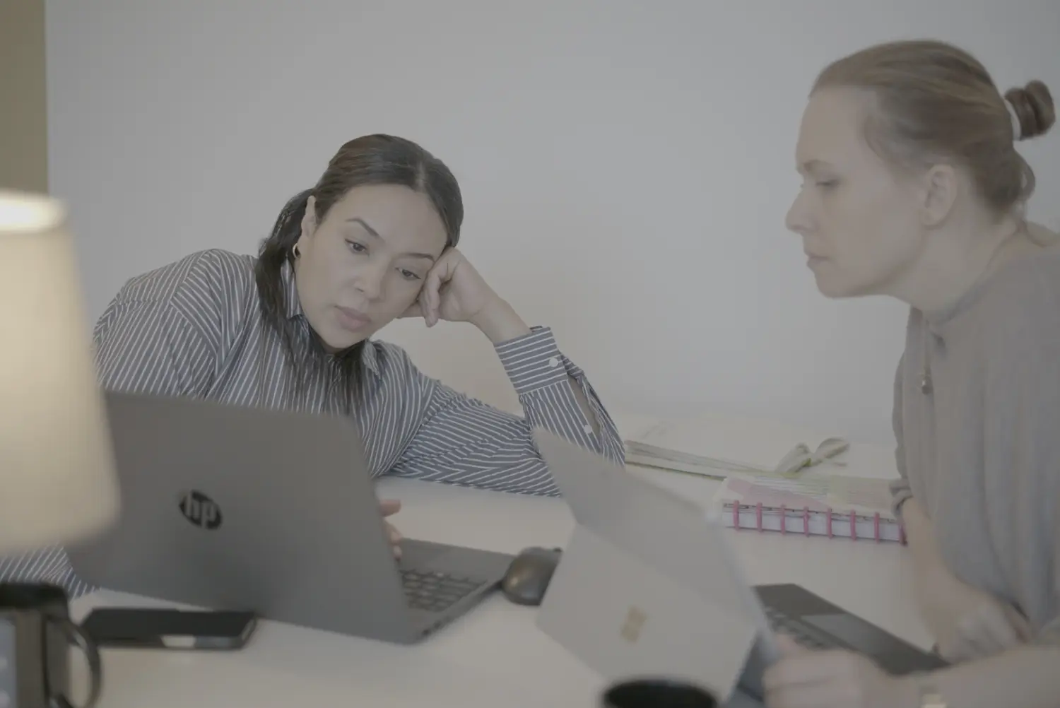 Thouraya und Wanda, die auf der Bank sitzen und Kaffeetassen halten